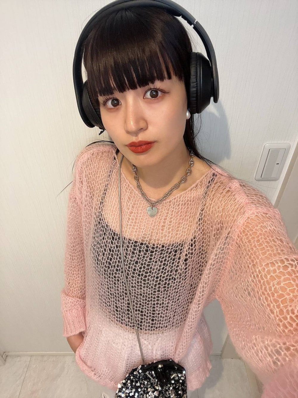 ピンク系のニット/セーター、シルバー系のネックレスを着用したレディースの秋コーディネートの3枚目の写真