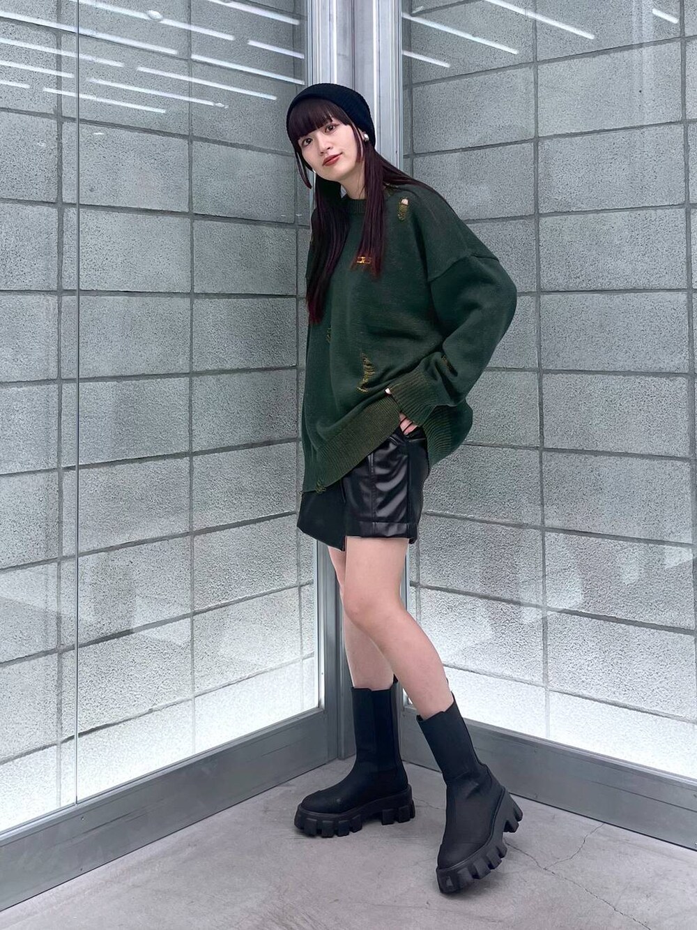 ブラック系のブーツ、ブラック系のその他パンツ、グリーン系のニット/セーターを着用したレディースの秋コーディネートの3枚目の写真