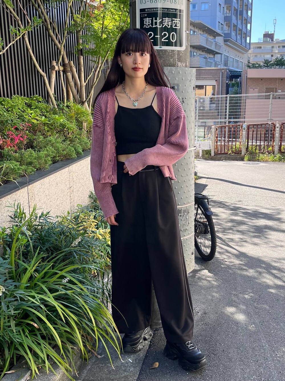 ブラック系のスニーカー、ブラック系のスラックス、ピンク系のカーディガン/ボレロを着用したレディースの秋コーディネートの2枚目の写真