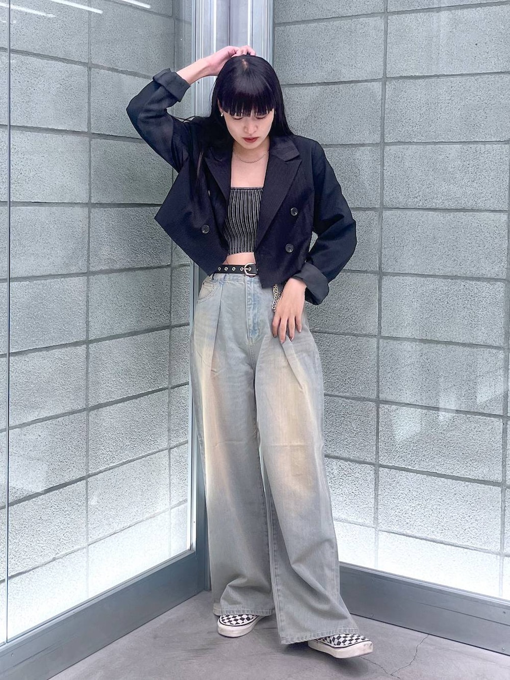 ブラック系のチューブトップ、ブルー系のデニムパンツ、ブラック系のテーラードジャケットを着用したレディースの夏コーディネートの2枚目の写真