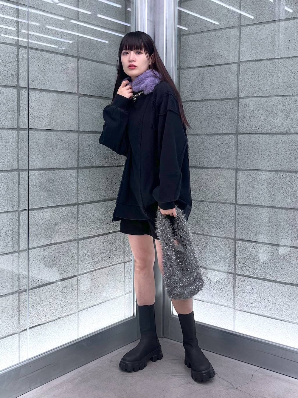 グレー系のハンドバッグ、ブラック系のスウェット、シルバー系のネックレスを着用したレディースの冬コーディネートの4枚目の写真