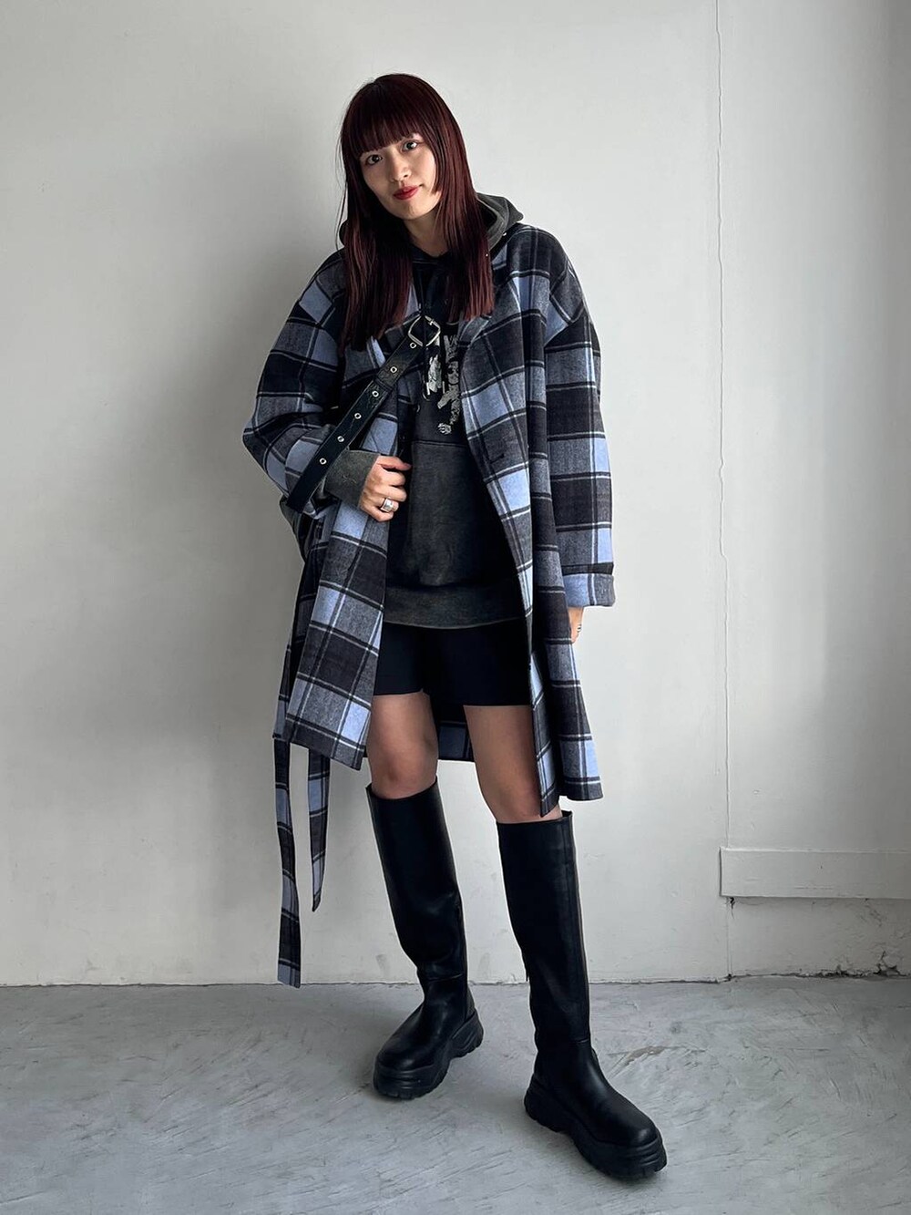 ブラック系のショルダーバッグ、ブラック系のブーツ、ブラック系のパーカーを着用したレディースの秋コーディネートの2枚目の写真