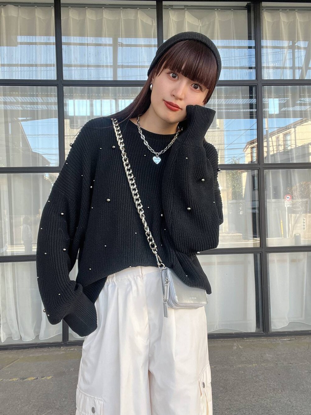 シルバー系のショルダーバッグ、ホワイト系のカーゴパンツ、ブラック系のニット/セーターを着用したレディースの秋コーディネートの3枚目の写真