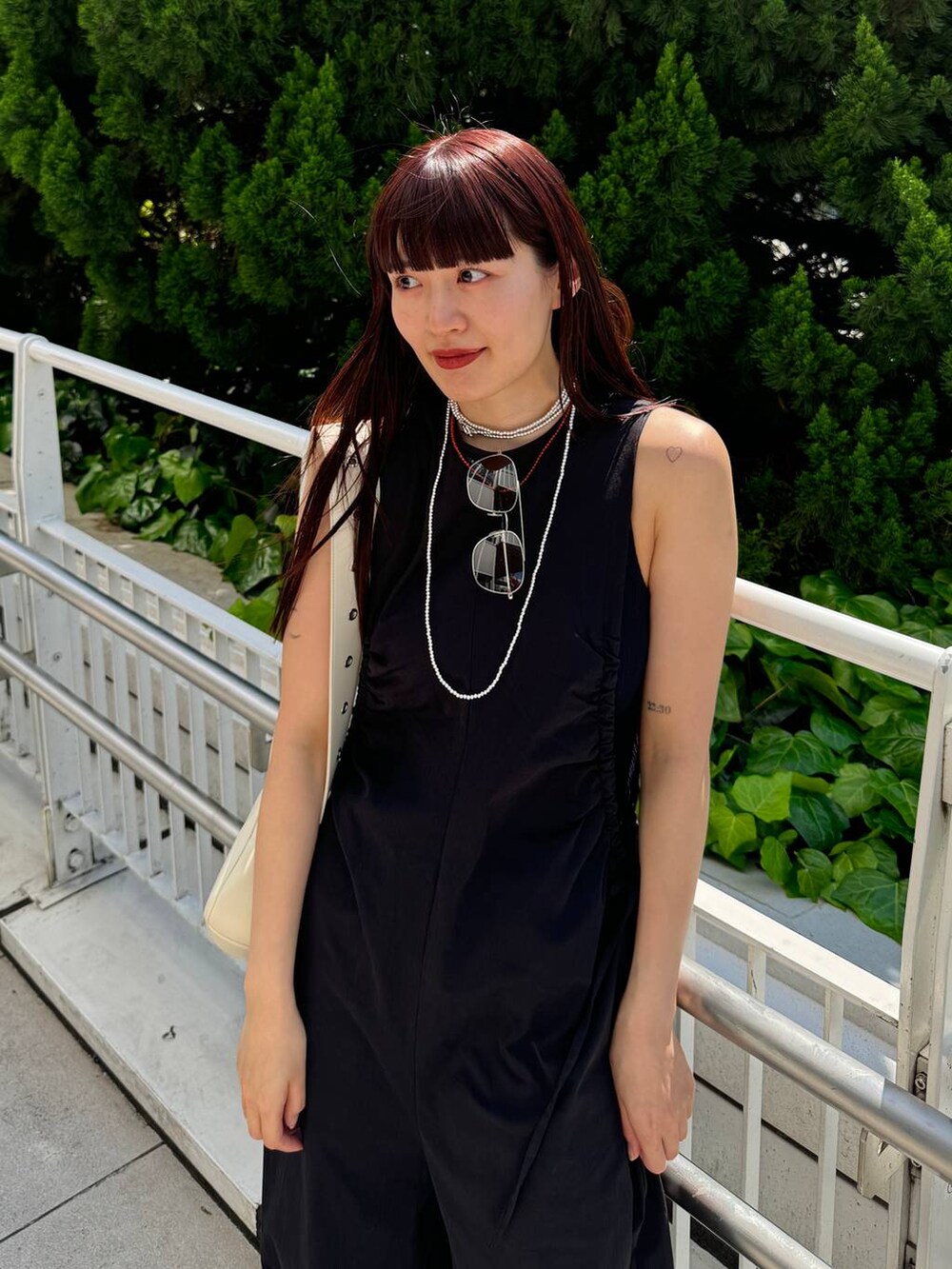 ホワイト系のショルダーバッグ、ブラック系のサロペット/オーバーオール、ブラック系のサンダルを着用したレディースの春コーディネートの3枚目の写真