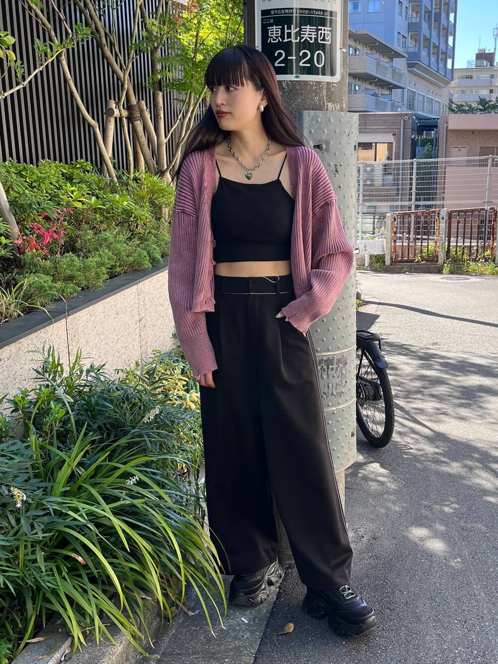 ブラック系のスニーカー、ブラック系のスラックス、ピンク系のカーディガン/ボレロを着用したレディースの秋コーディネートの4枚目の写真