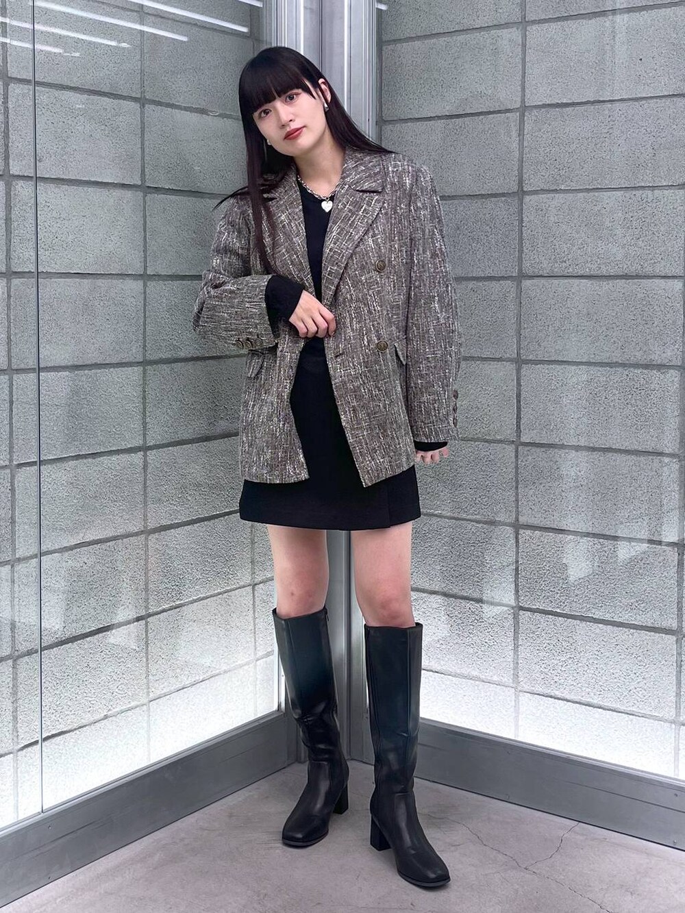 グレー系のテーラードジャケット、ブラック系のその他パンツを着用したレディースの秋コーディネートの3枚目の写真