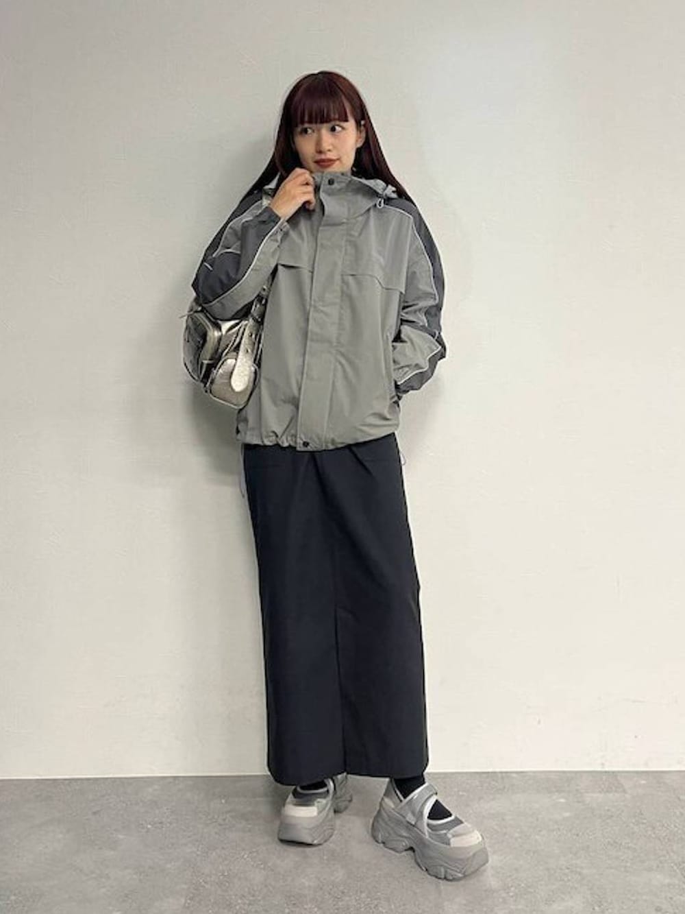 シルバー系のスニーカー、シルバー系のショルダーバッグ、ブラック系のセットアップを着用したレディースの秋コーディネートの2枚目の写真