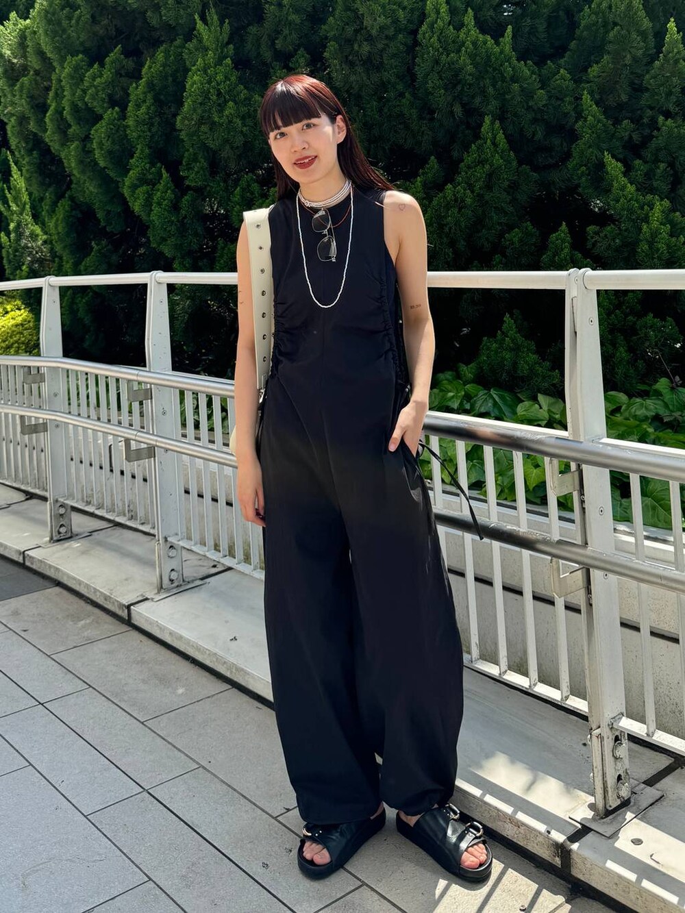 ホワイト系のショルダーバッグ、ブラック系のサロペット/オーバーオール、ブラック系のサンダルを着用したレディースの春コーディネートの2枚目の写真