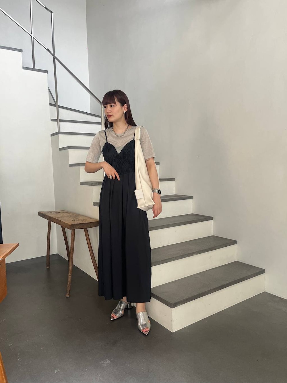 シルバー系のサンダル、シルバー系のTシャツ/カットソー、ブラック系のワンピースを着用したレディースの春コーディネートの4枚目の写真