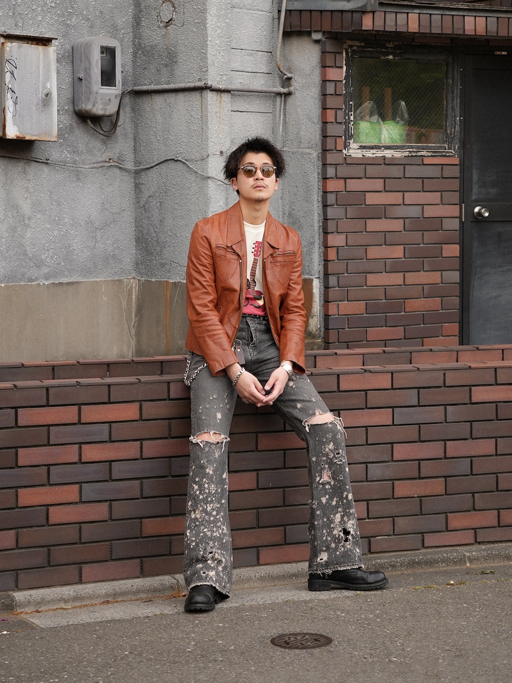 ブラック系のデニムパンツ、ベージュ系のTシャツ/カットソー、オレンジ系のジャケット/アウターを着用したメンズの春コーディネートの5枚目の写真