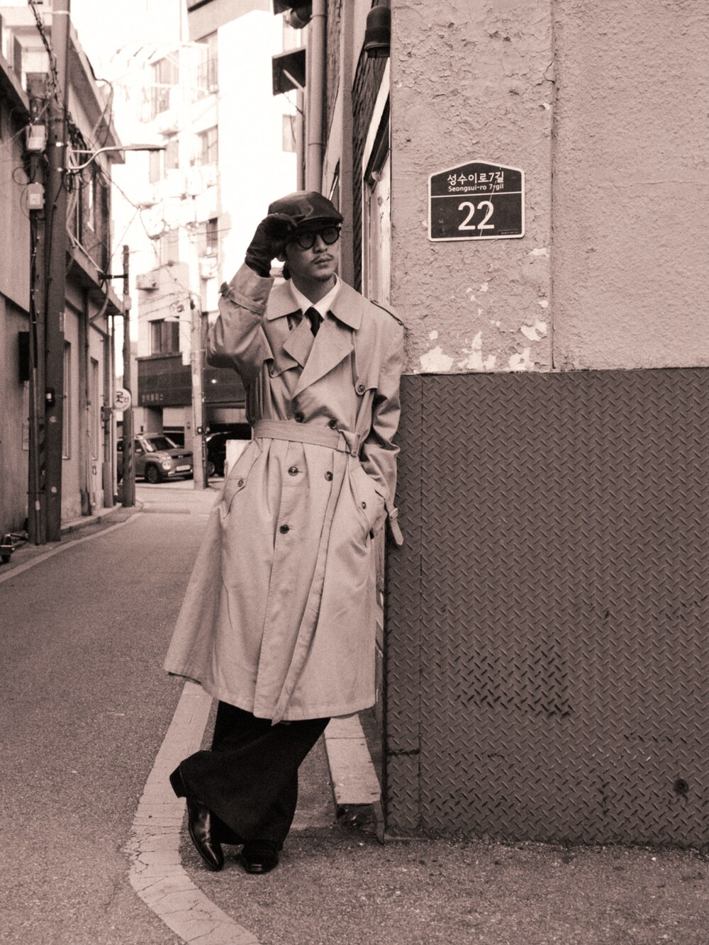 ベージュ系のトレンチコート、ブラック系のデニムパンツ、ブラック系のブーツを着用したメンズの秋コーディネートの3枚目の写真