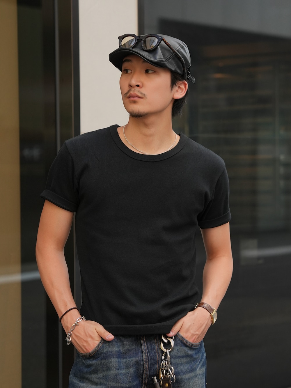 ブルー系のデニムパンツ、ブラック系のTシャツ/カットソー、ブラック系のブーツを着用したメンズの夏コーディネートの4枚目の写真