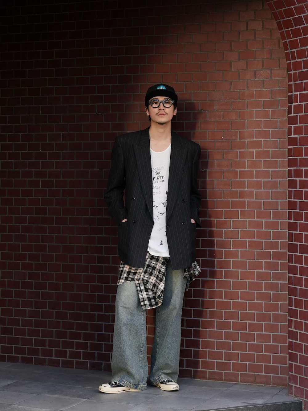 ブラック系のテーラードジャケット、ホワイト系のタンクトップ、ブルー系のデニムパンツを着用したメンズの冬コーディネートの5枚目の写真