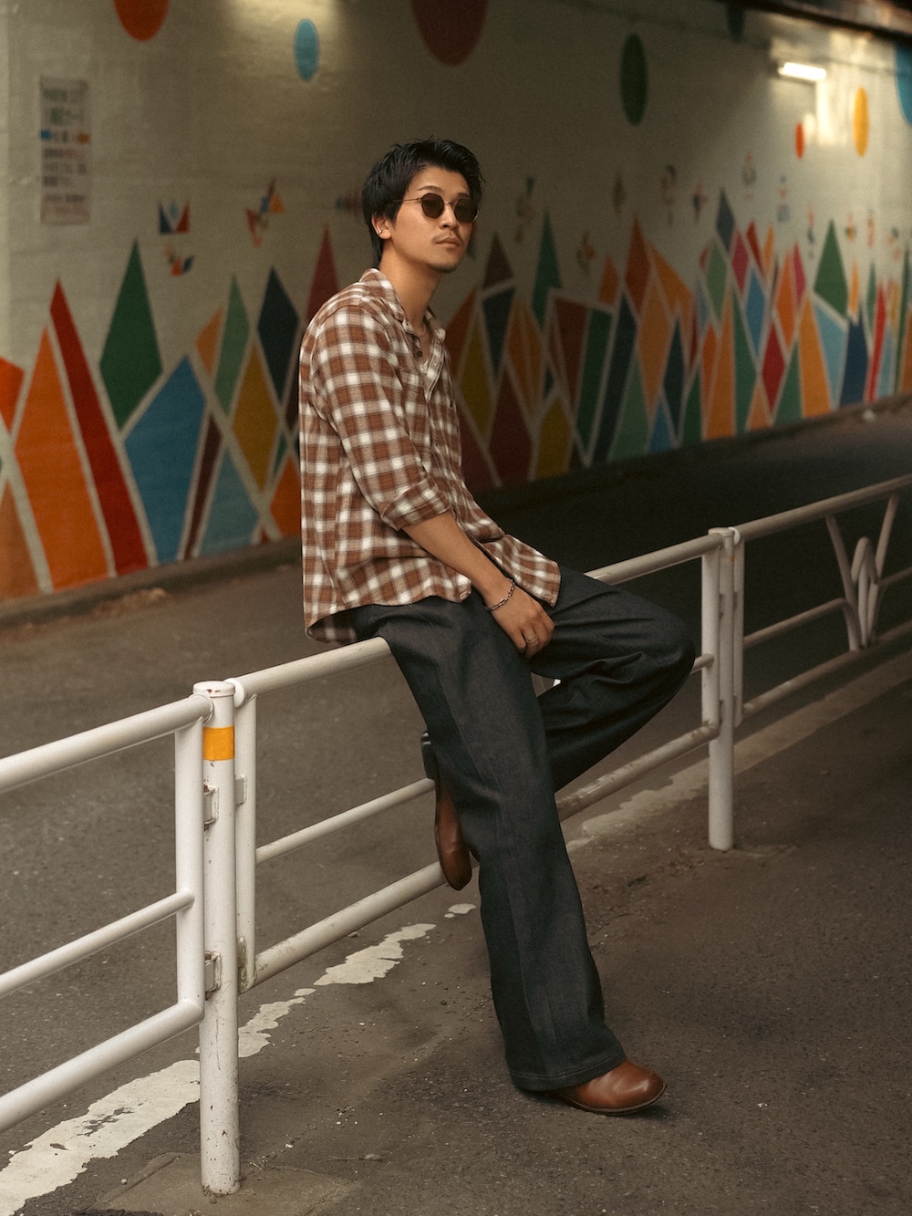 ホワイト系のタンクトップ、ブラック系のデニムパンツ、ブラウン系のブーツを着用したメンズの秋コーディネートの3枚目の写真