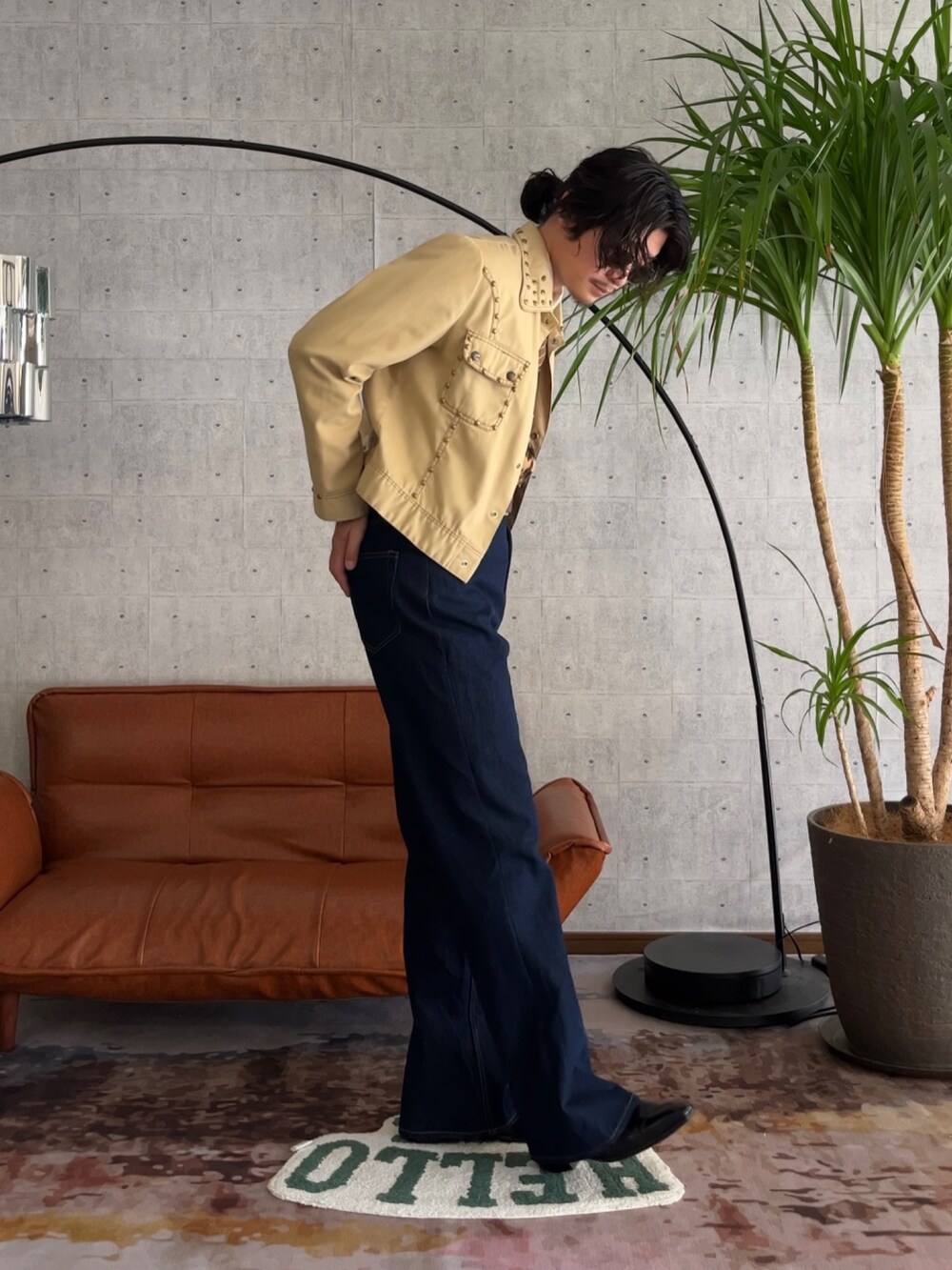 ブルー系のデニムパンツ、ゴールド系のカーディガン/ボレロ、ベージュ系のブルゾンを着用したメンズの秋コーディネートの3枚目の写真