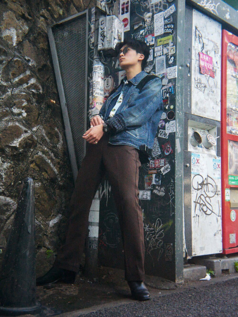 ブラウン系のデニムパンツ、ブラック系のドレスシューズ、ブルー系のシャツ/ブラウスを着用したメンズの春コーディネートの3枚目の写真