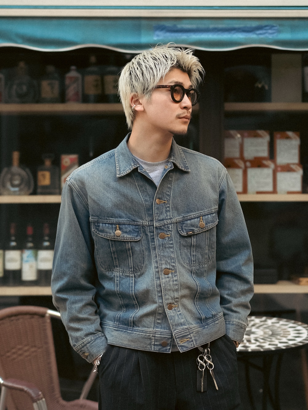 ブラック系のスラックス、ブラック系のブーツ、ブルー系のデニムジャケットを着用したメンズの冬コーディネートの2枚目の写真