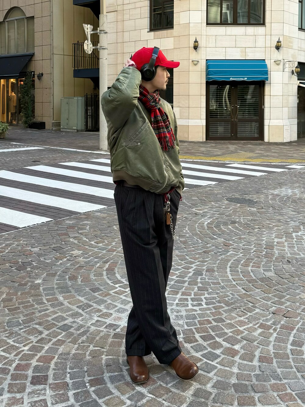 ブラック系のスラックス、ブラウン系のブーツ、グリーン系のMA-1を着用したメンズの冬コーディネートの4枚目の写真