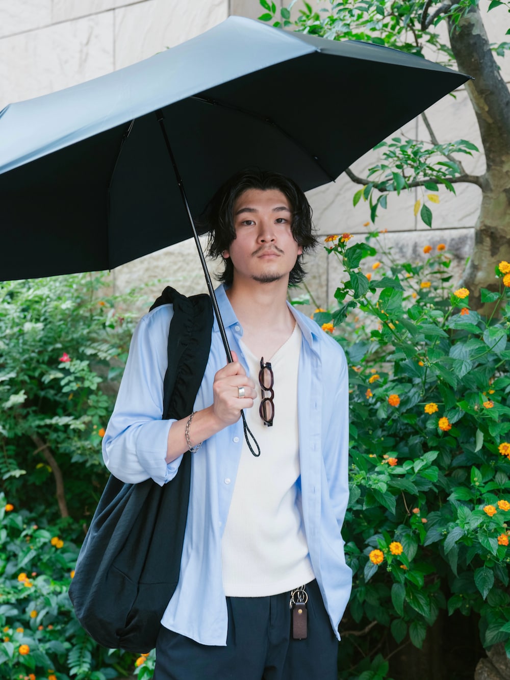 ホワイト系のタンクトップ、ブラック系のショルダーバッグ、ブラック系のスニーカーを着用したメンズの夏コーディネートの2枚目の写真