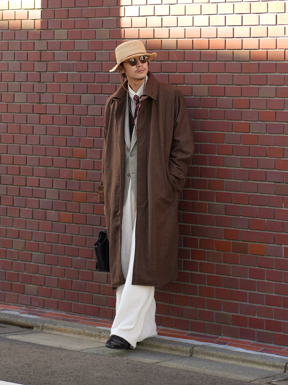 ブラック系のハンドバッグ、ホワイト系のその他パンツ、ブラック系のドレスシューズを着用したメンズの秋コーディネートの5枚目の写真