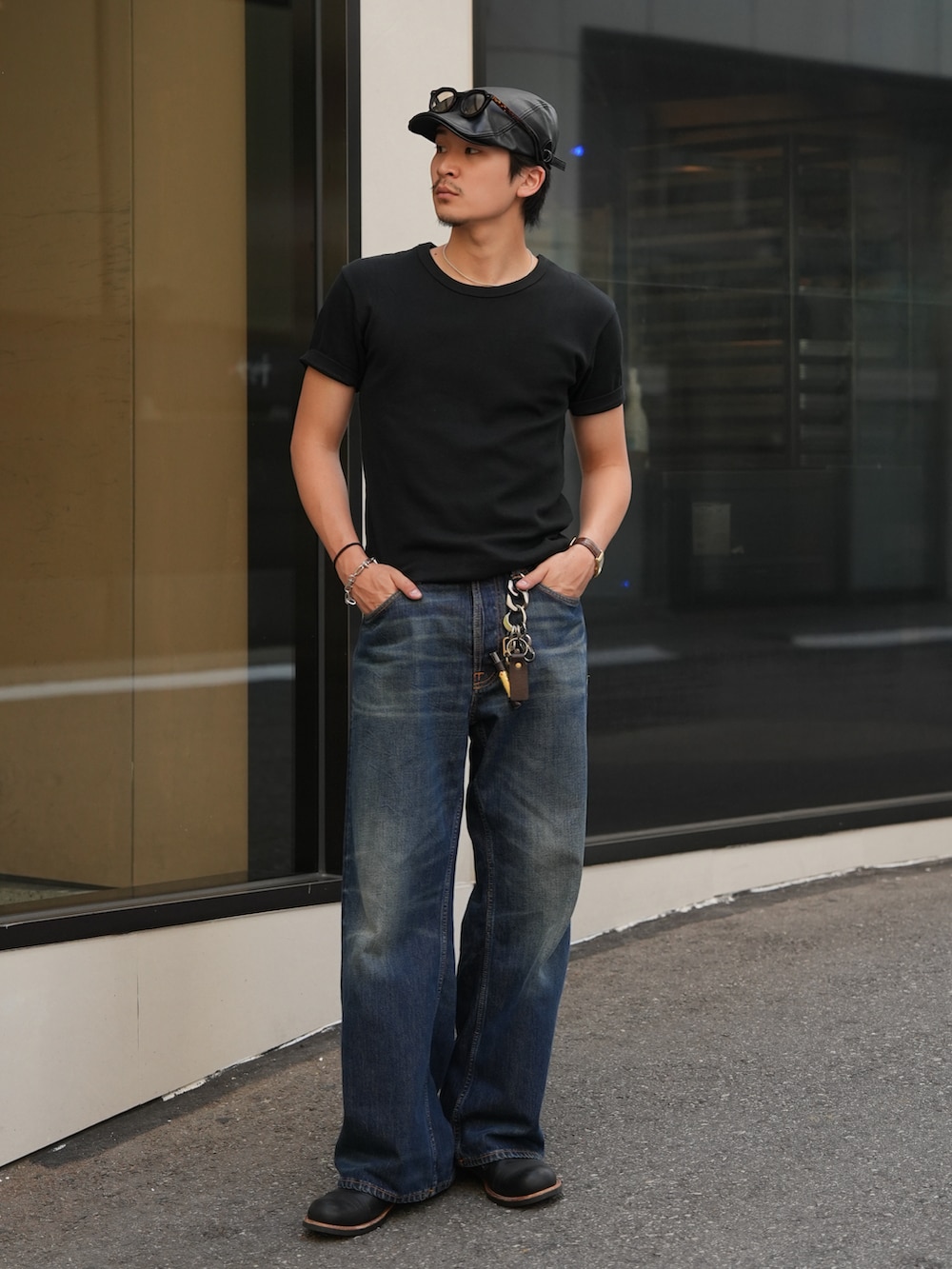 ブルー系のデニムパンツ、ブラック系のTシャツ/カットソー、ブラック系のブーツを着用したメンズの夏コーディネートの5枚目の写真