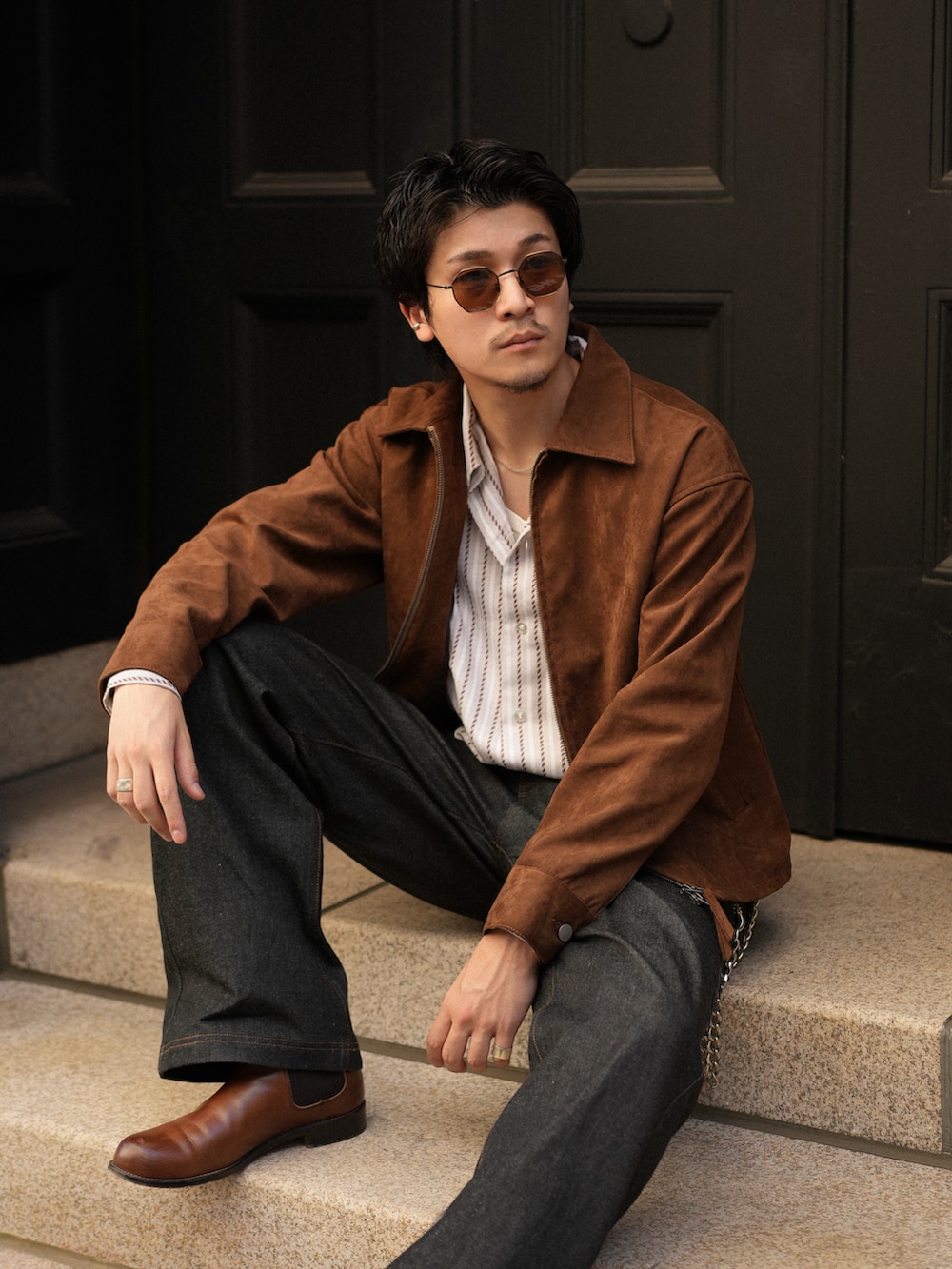 ブラック系のデニムパンツ、ブラウン系のブーツ、ホワイト系のシャツ/ブラウスを着用したメンズの秋コーディネートの2枚目の写真