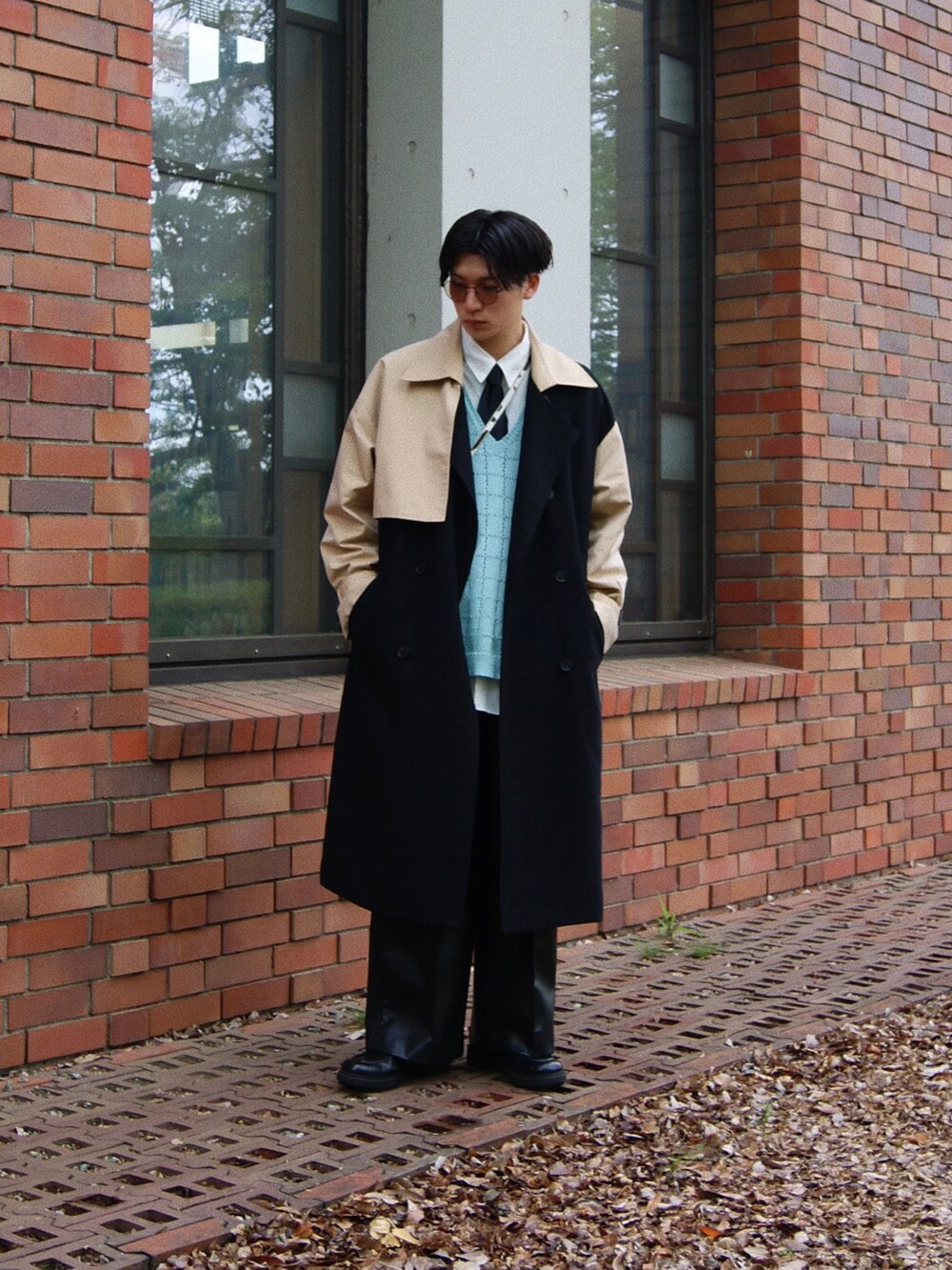 ブラック系のトレンチコート、ブルー系のベスト、ブラック系のドレスシューズを着用したメンズの春コーディネートの3枚目の写真