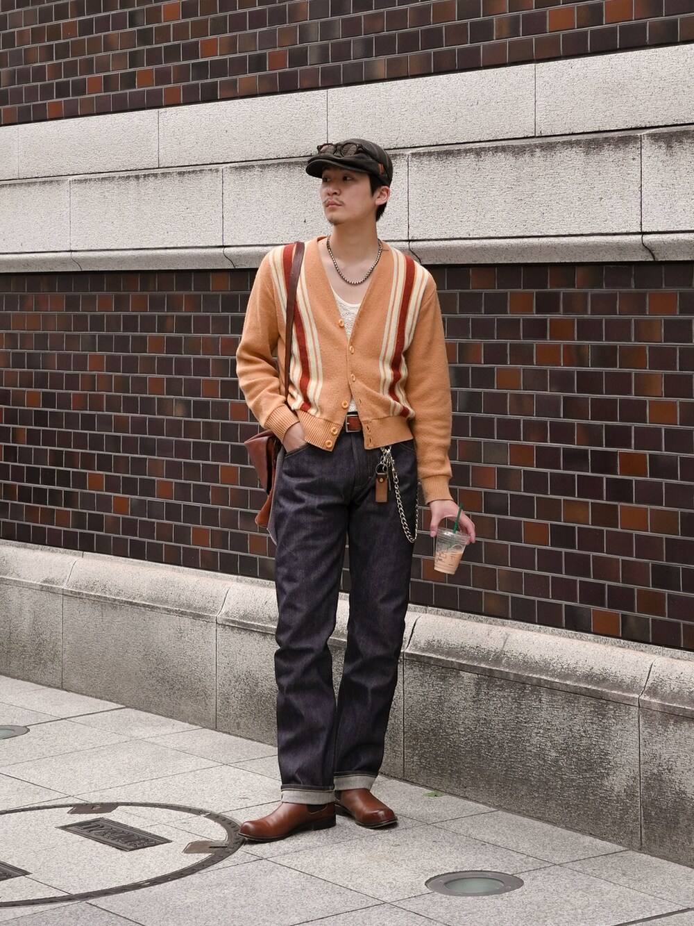 その他のデニムパンツ、ブラウン系のブーツ、ブラウン系のショルダーバッグを着用したメンズの春コーディネートの2枚目の写真