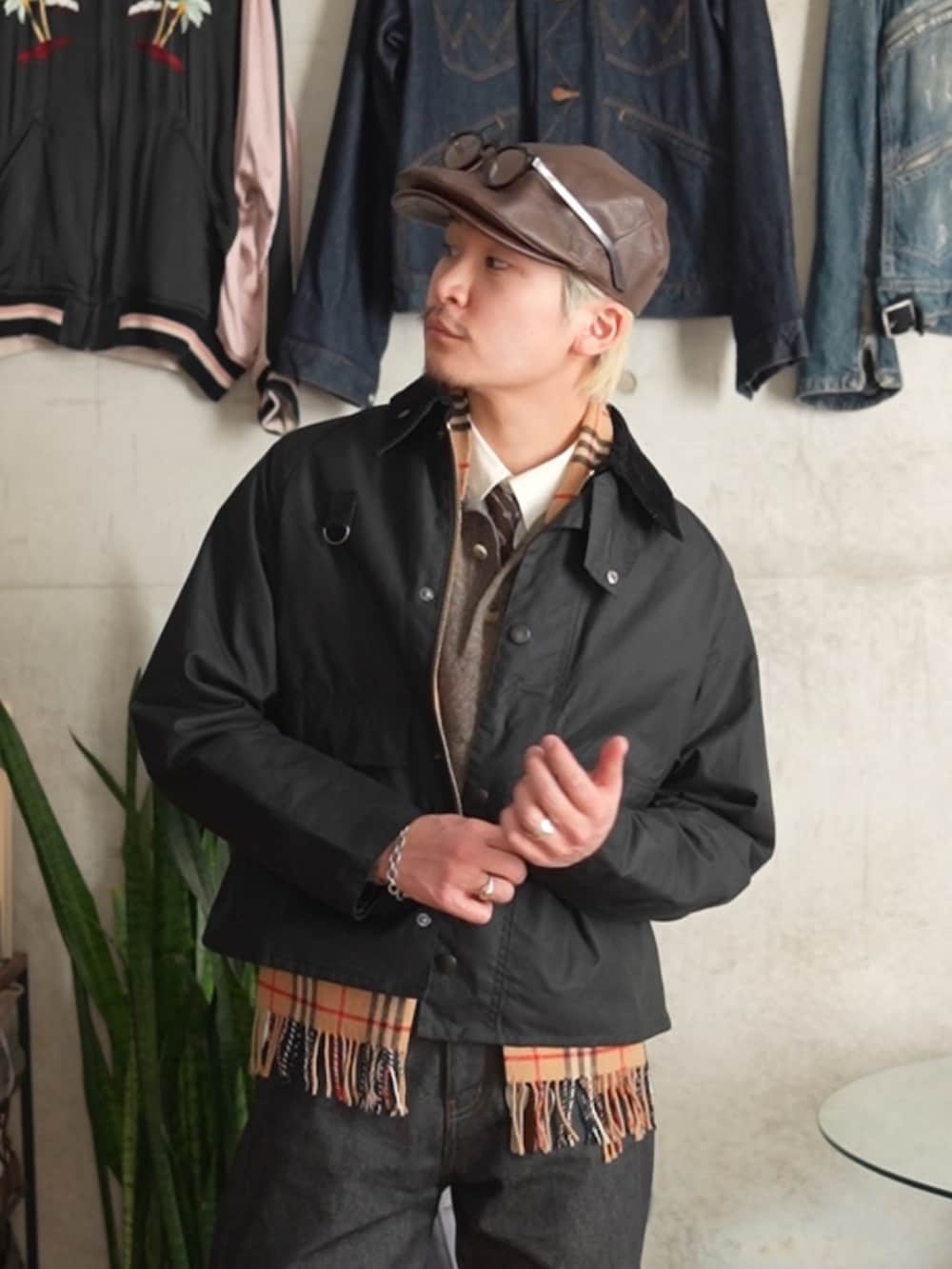 ブラック系のデニムパンツ、ブラック系のブルゾン、ベージュ系のニット/セーターを着用したメンズの冬コーディネートの2枚目の写真