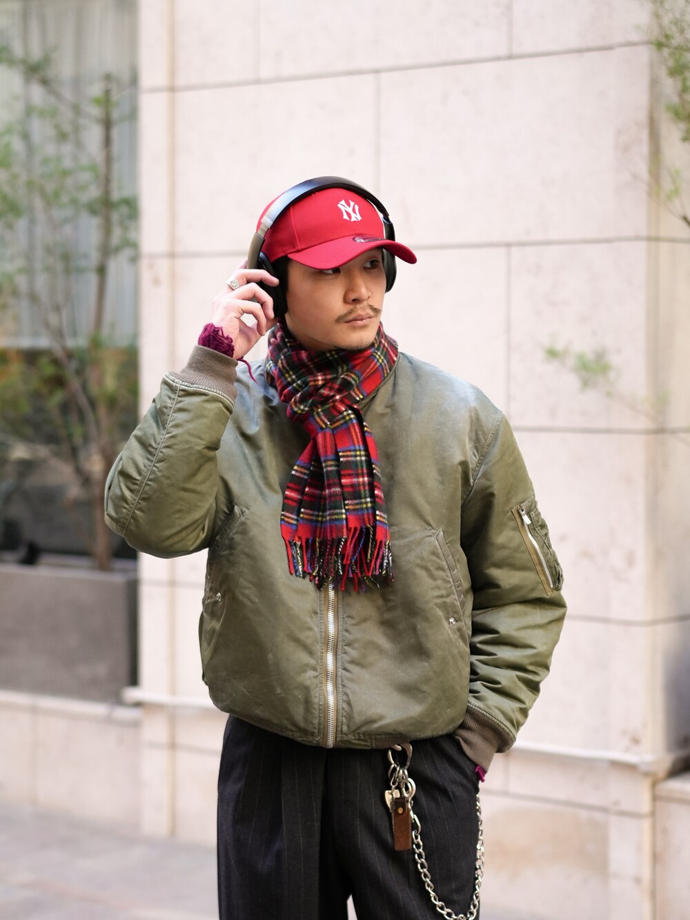 ブラック系のスラックス、ブラウン系のブーツ、グリーン系のMA-1を着用したメンズの冬コーディネートの2枚目の写真