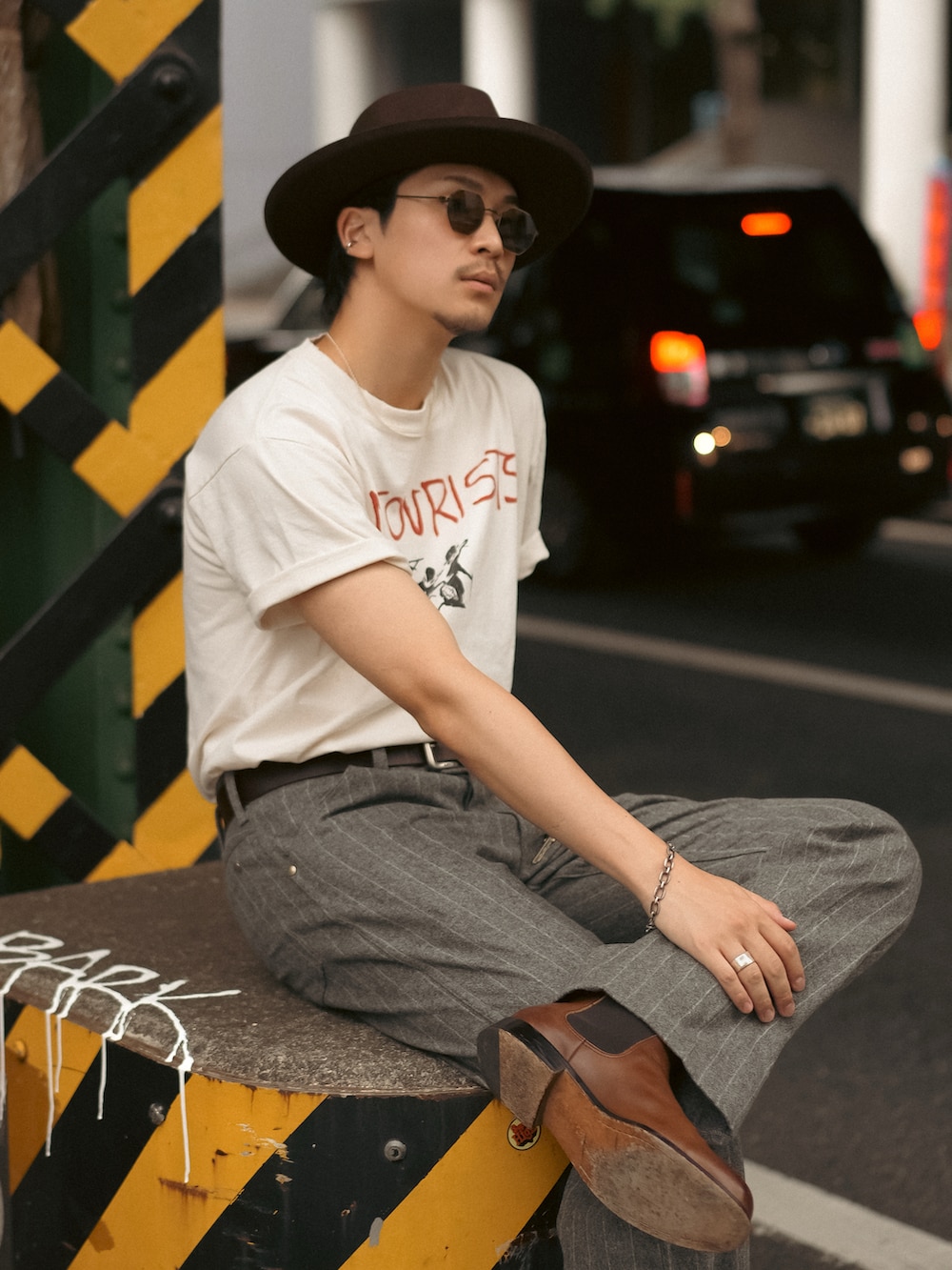 グレー系のその他パンツ、ホワイト系のTシャツ/カットソー、ブラウン系のブーツを着用したメンズの夏コーディネートの2枚目の写真