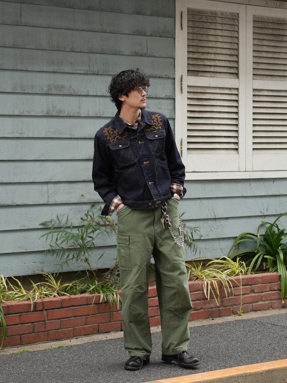 グリーン系のカーゴパンツ、ブラック系のブーツ、ブルー系のデニムジャケットを着用したメンズの春コーディネートの5枚目の写真