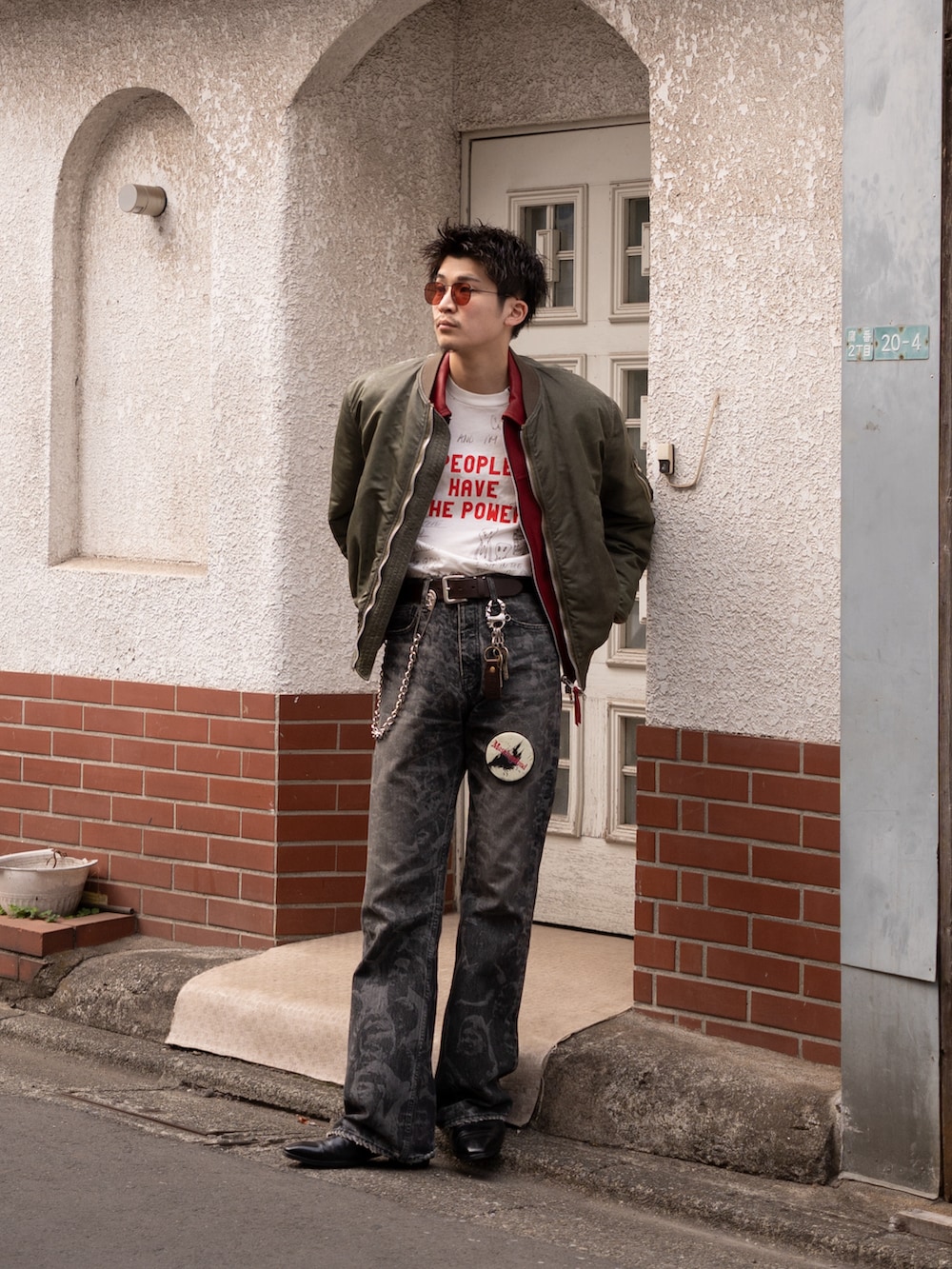 ブラック系のデニムパンツ、ブラック系のブーツ、グリーン系のMA-1を着用したメンズの春コーディネートの3枚目の写真