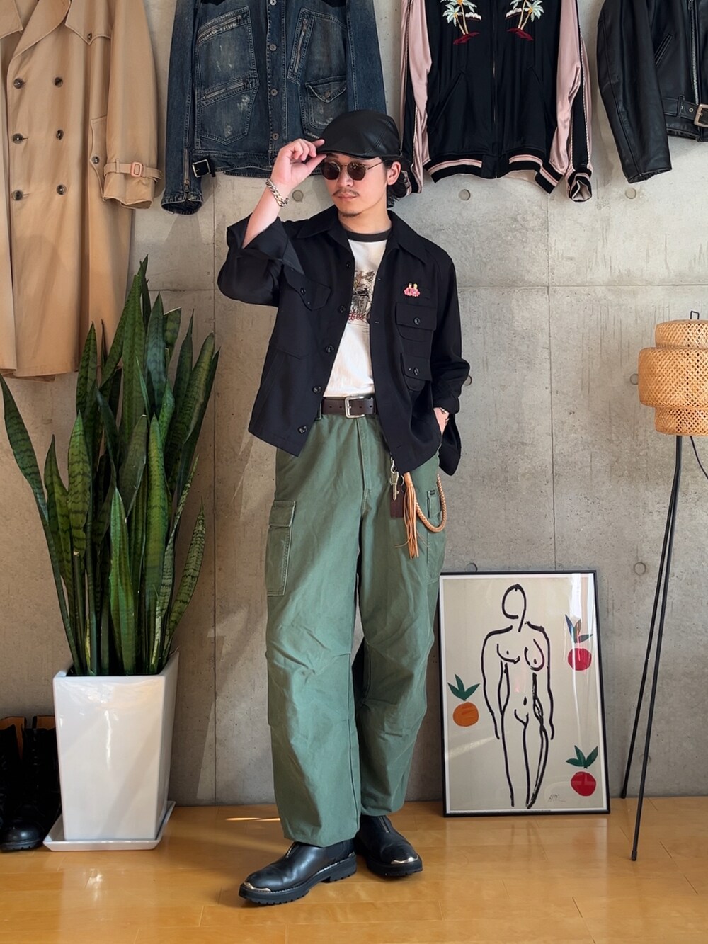 グリーン系のカーゴパンツ、ブラック系のTシャツ/カットソー、ブラック系のミリタリージャケットを着用したメンズの秋コーディネートの3枚目の写真