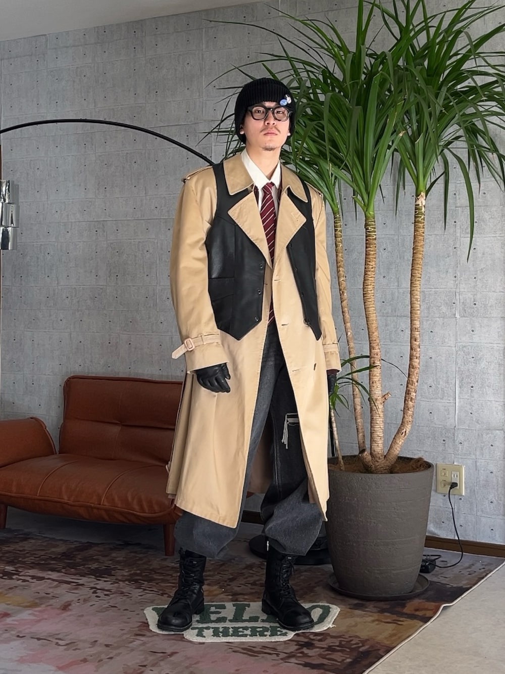 ブラック系のブーツ、ブラック系のデニムパンツ、ベージュ系のトレンチコートを着用したメンズの冬コーディネートの2枚目の写真