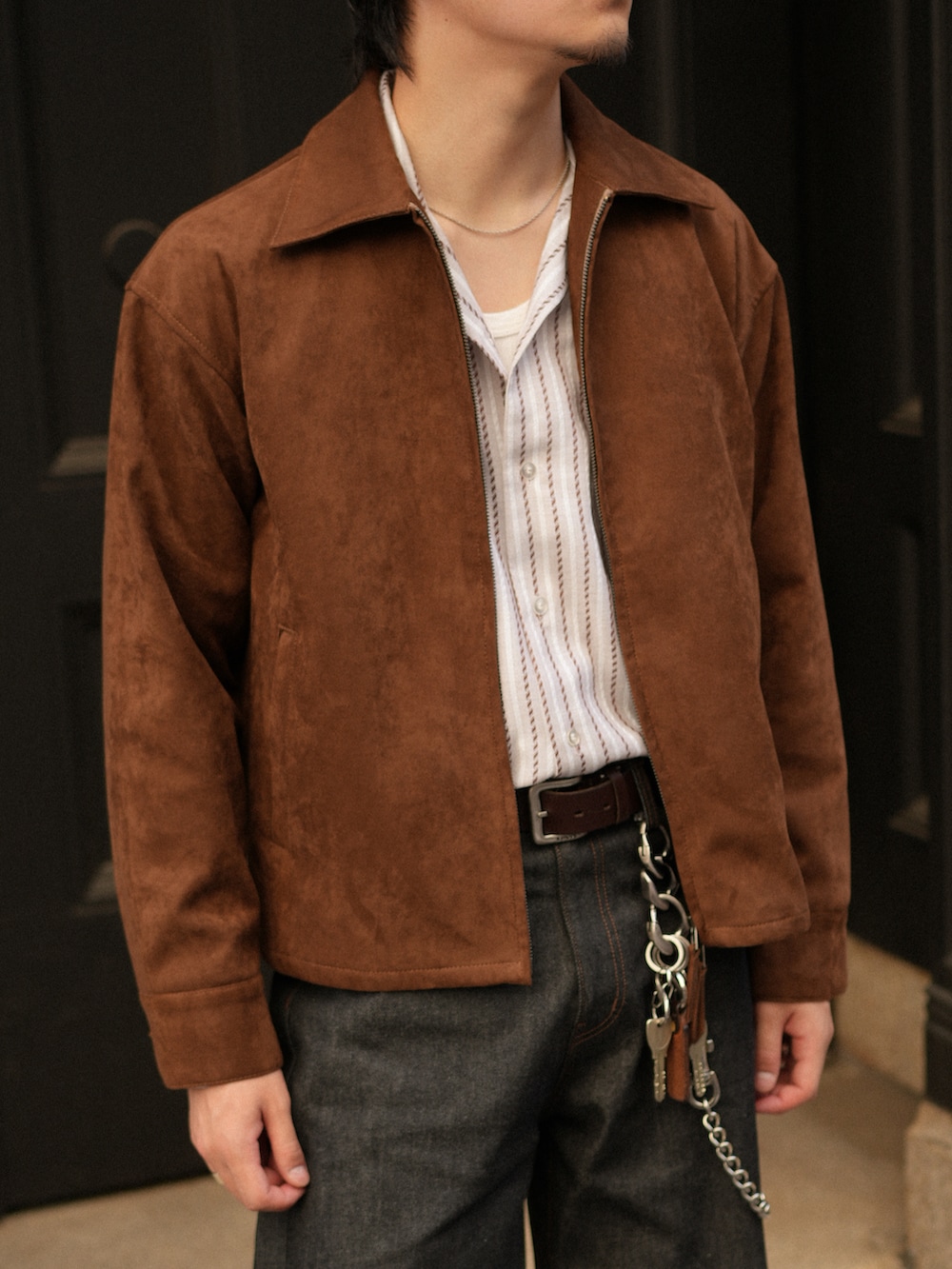 ブラック系のデニムパンツ、ブラウン系のブーツ、ホワイト系のシャツ/ブラウスを着用したメンズの秋コーディネートの4枚目の写真