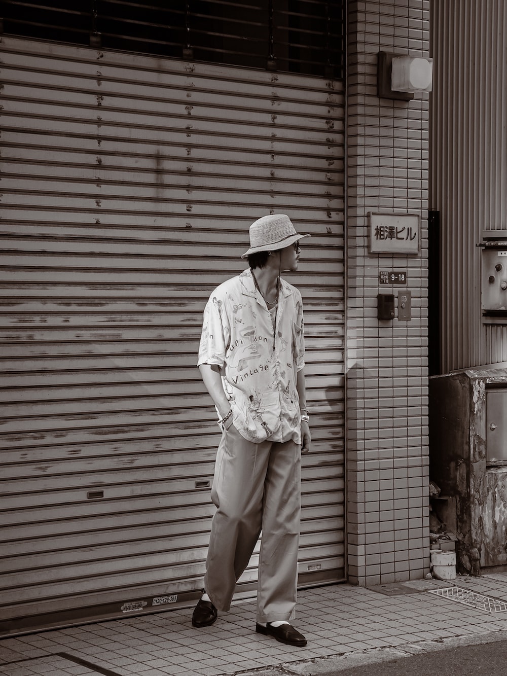 グレー系のシャツ/ブラウス、ベージュ系のチノパンツ、ブラック系のスリッポンを着用したメンズの夏コーディネートの4枚目の写真