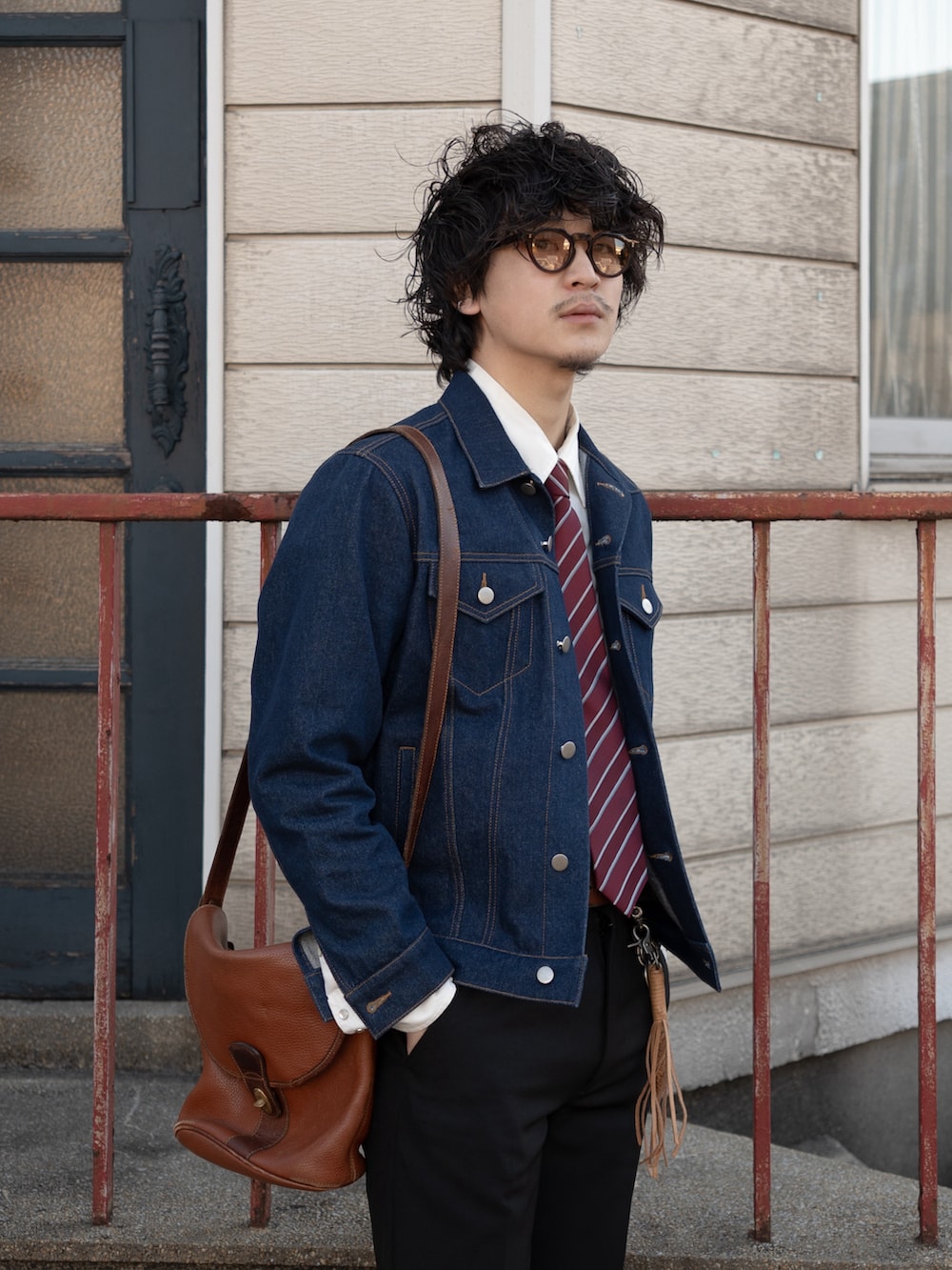 ブラック系のスラックス、ブラウン系のショルダーバッグ、ブラウン系のドレスシューズを着用したメンズの冬コーディネートの2枚目の写真