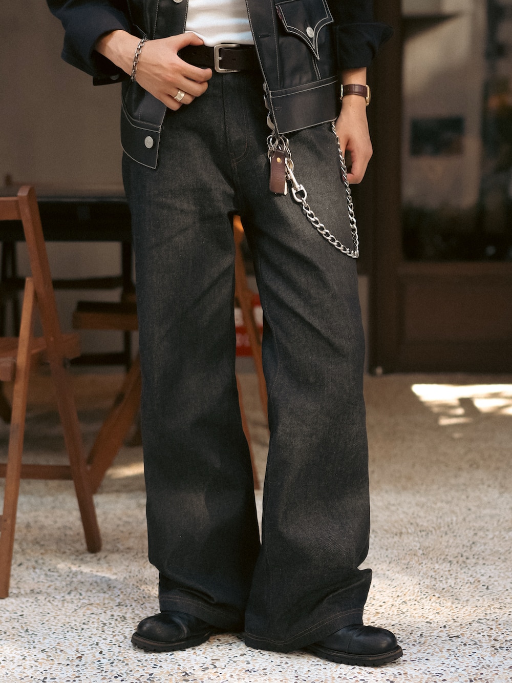 ブラック系のデニムパンツ、ブラック系のブルゾン、ホワイト系のタンクトップを着用したメンズの秋コーディネートの4枚目の写真