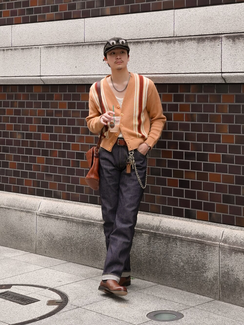その他のデニムパンツ、ブラウン系のブーツ、ブラウン系のショルダーバッグを着用したメンズの春コーディネートの5枚目の写真