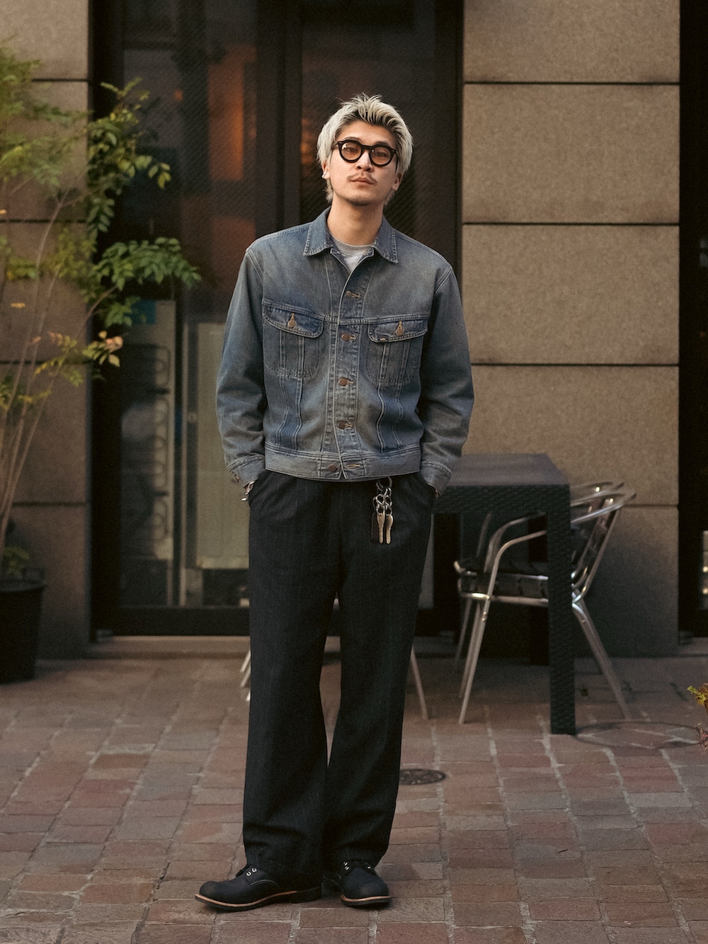 ブラック系のスラックス、ブラック系のブーツ、ブルー系のデニムジャケットを着用したメンズの冬コーディネートの5枚目の写真