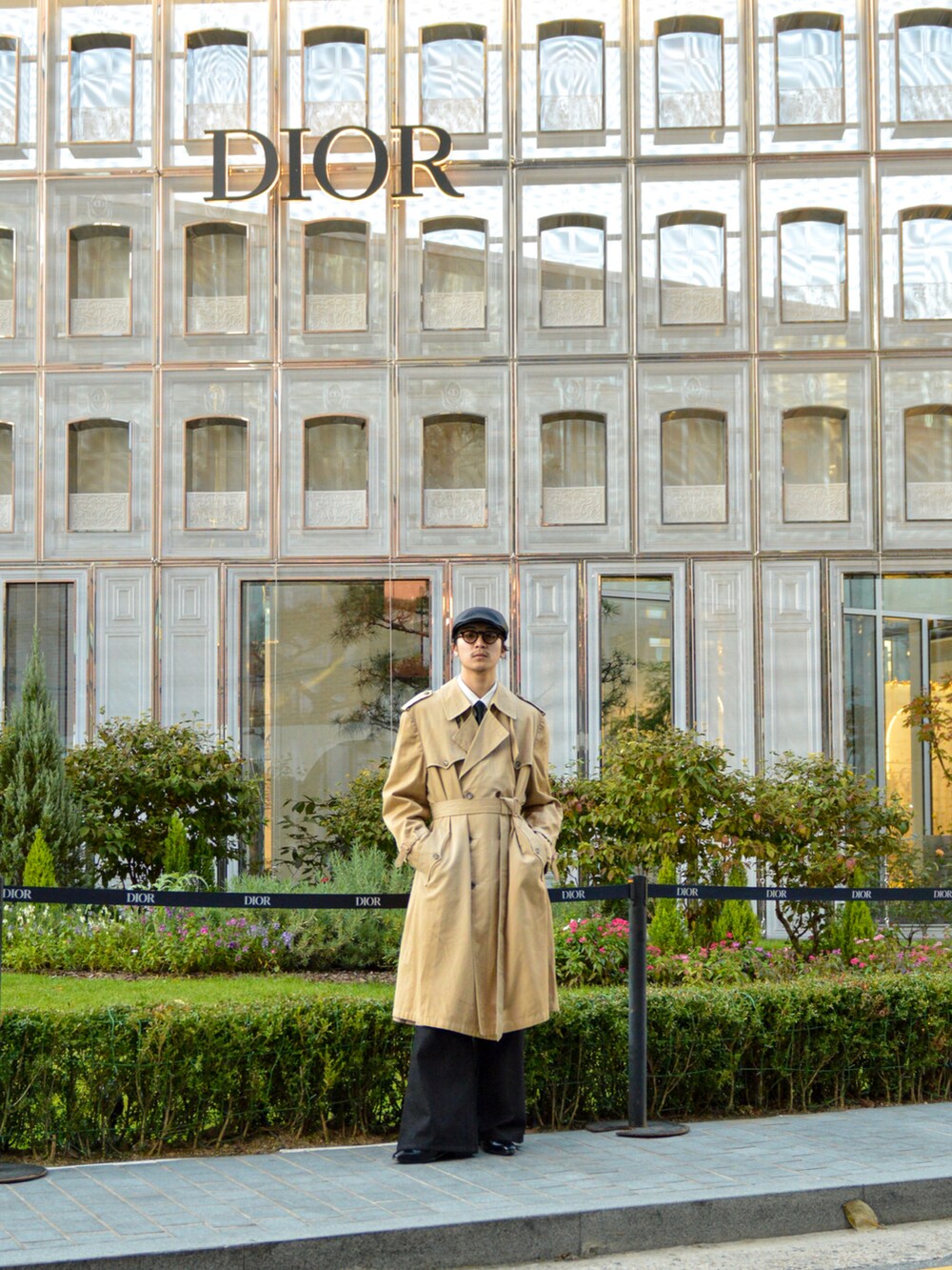 ベージュ系のトレンチコート、ブラック系のデニムパンツ、ブラック系のブーツを着用したメンズの秋コーディネートの2枚目の写真