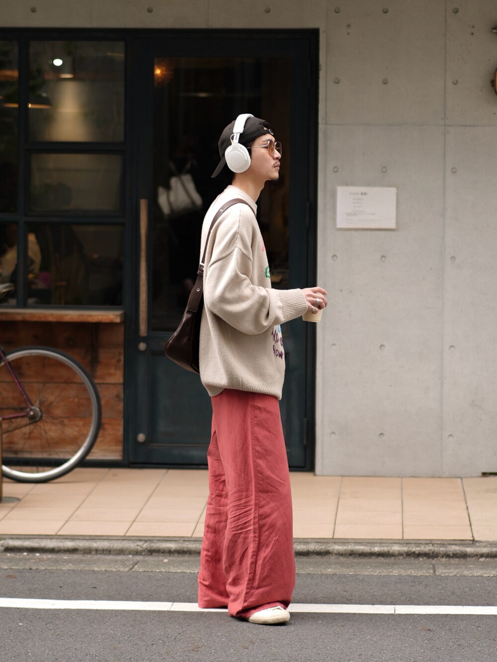 ピンク系のパンツ、ホワイト系のスニーカー、ブラウン系のショルダーバッグを着用したメンズの春コーディネートの5枚目の写真