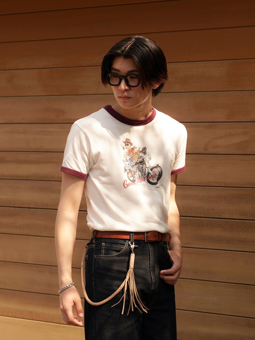 ブルー系のデニムパンツ、ブラック系のブーツ、レッド系のTシャツ/カットソーを着用したメンズの春コーディネートの4枚目の写真