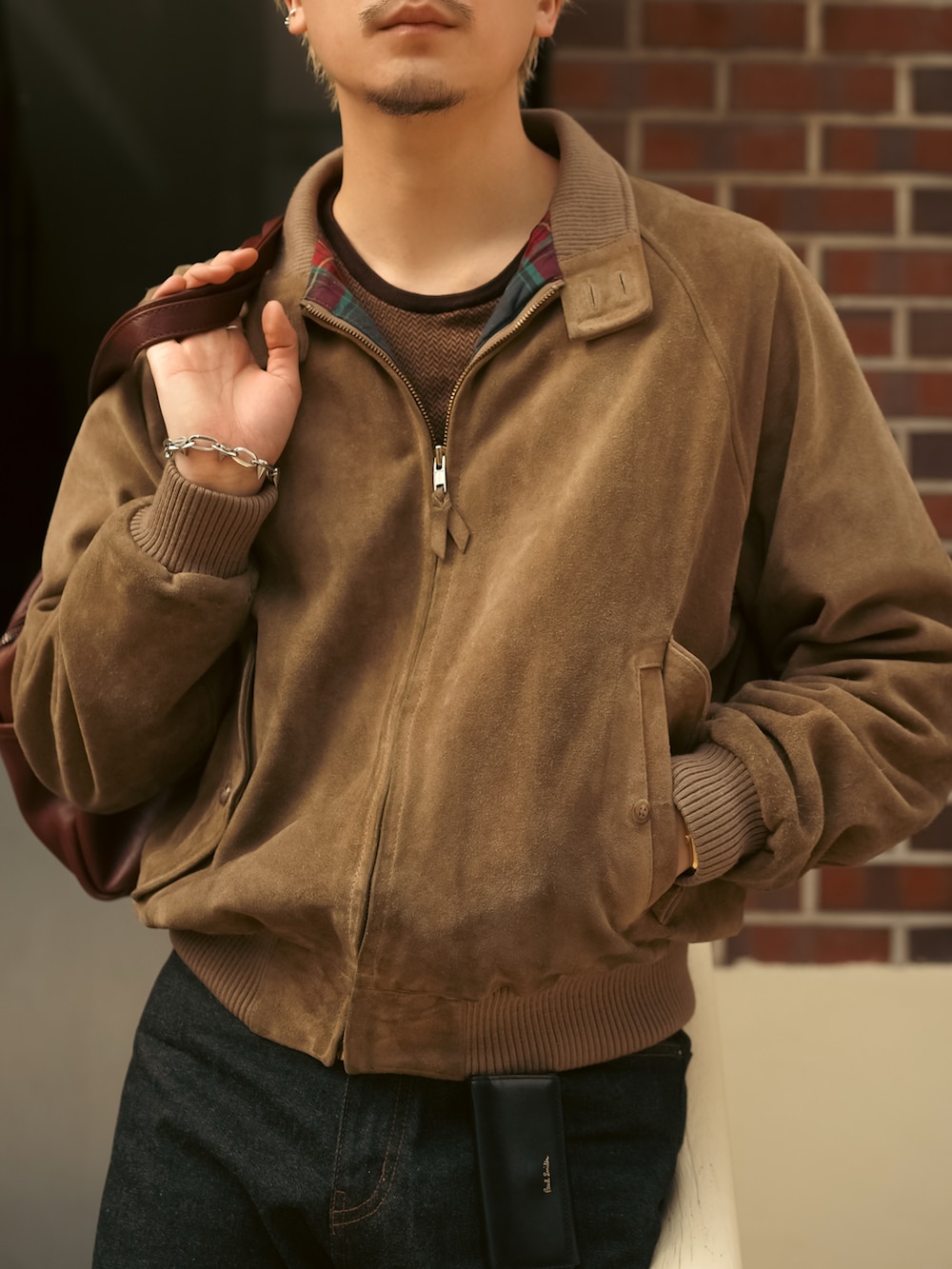 ブラック系のデニムパンツ、ブラック系のブーツ、ブラウン系のブルゾンを着用したメンズの春コーディネートの3枚目の写真