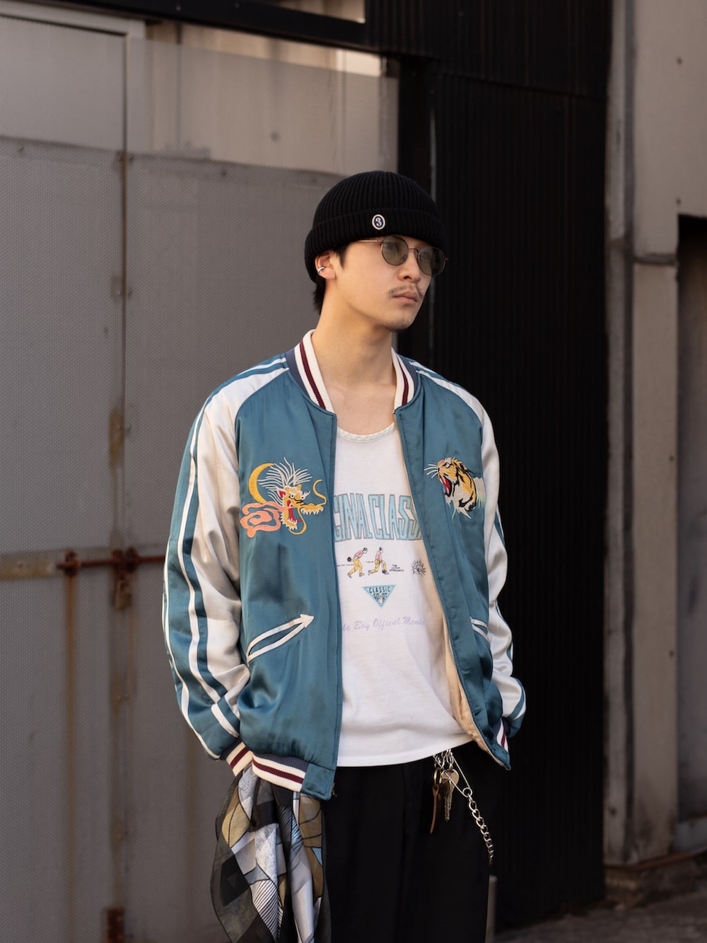 ブラック系のその他パンツ、ブラック系のブーツ、ブルー系のスカジャンを着用したメンズの春コーディネートの2枚目の写真