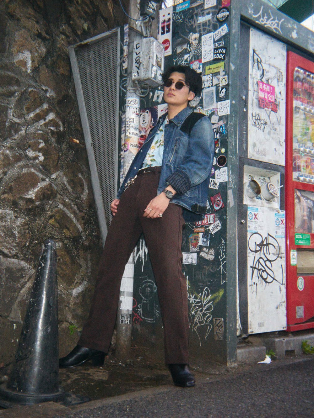 ブラウン系のデニムパンツ、ブラック系のドレスシューズ、ブルー系のシャツ/ブラウスを着用したメンズの春コーディネートの2枚目の写真