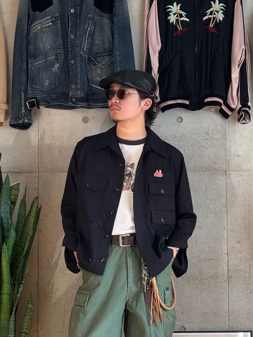 グリーン系のカーゴパンツ、ブラック系のTシャツ/カットソー、ブラック系のミリタリージャケットを着用したメンズの秋コーディネートの2枚目の写真