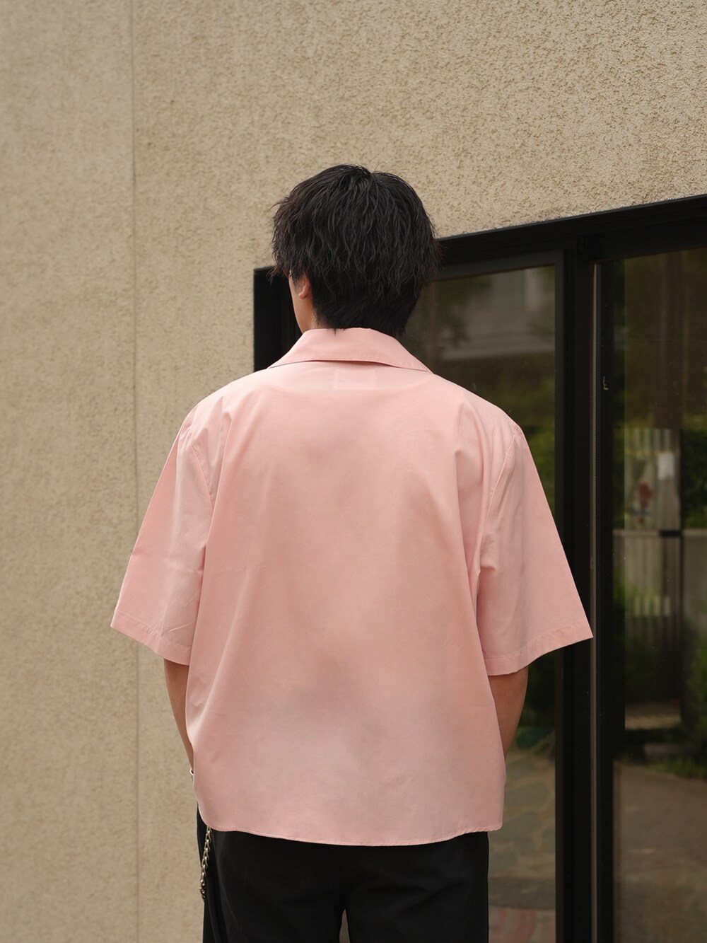 ブラック系のスラックス、ブラック系のスリッポン、ピンク系のシャツ/ブラウスを着用したメンズの夏コーディネートの5枚目の写真