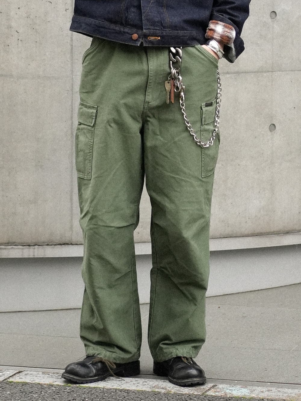 グリーン系のカーゴパンツ、ブラック系のブーツ、ブルー系のデニムジャケットを着用したメンズの春コーディネートの4枚目の写真